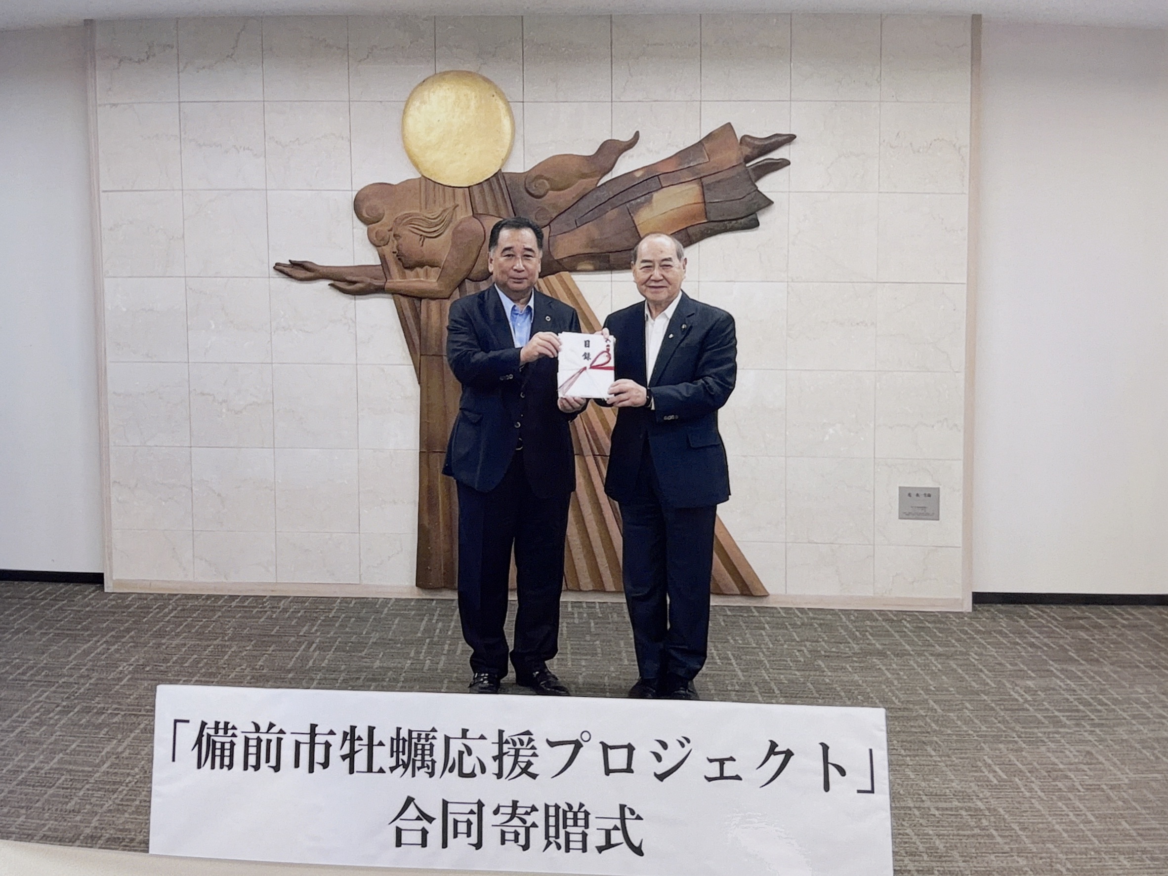 備前市役所での合同寄贈式の様子（長﨑市長と当社延原会長）